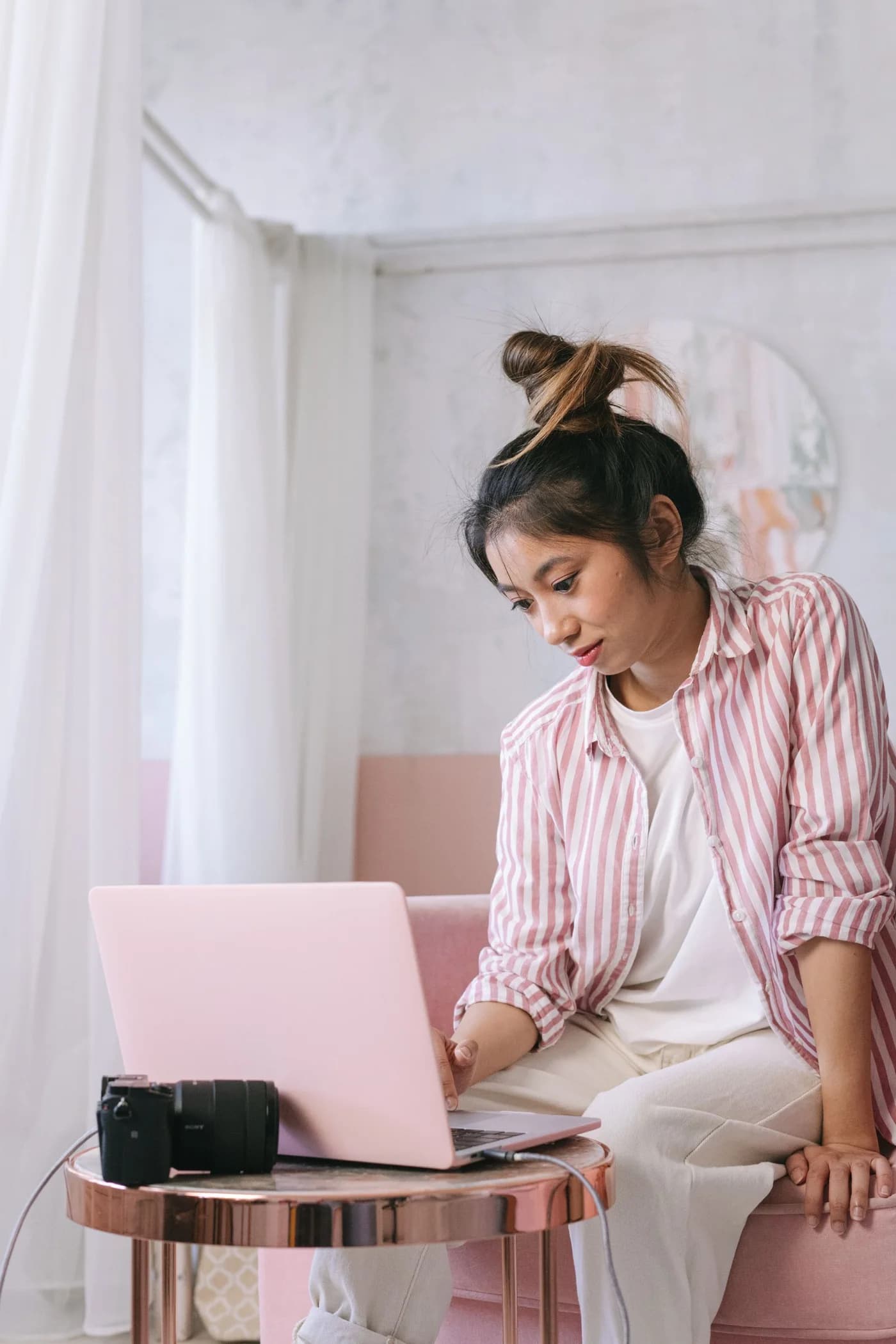 A woman writing on a laptop at home.