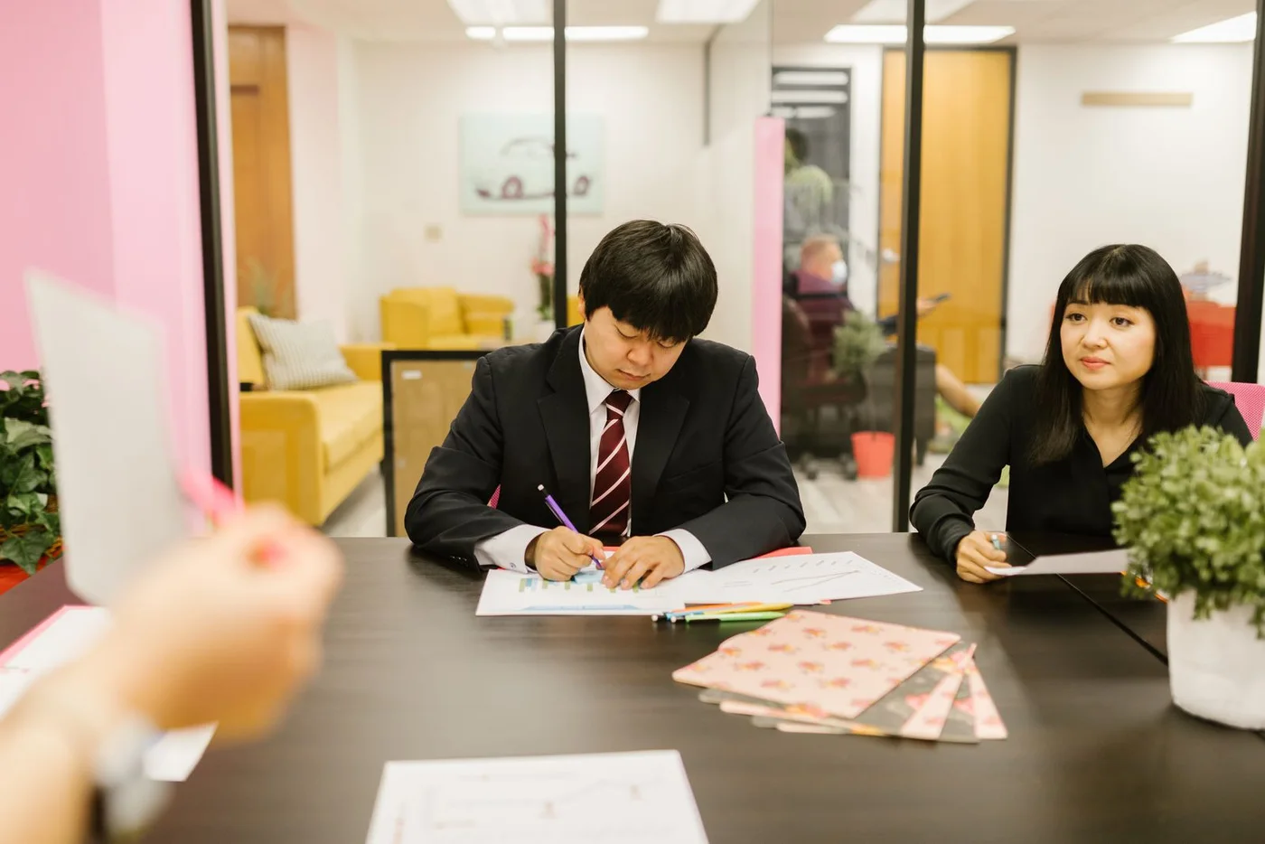 Colleagues discussing notes during an office meeting.