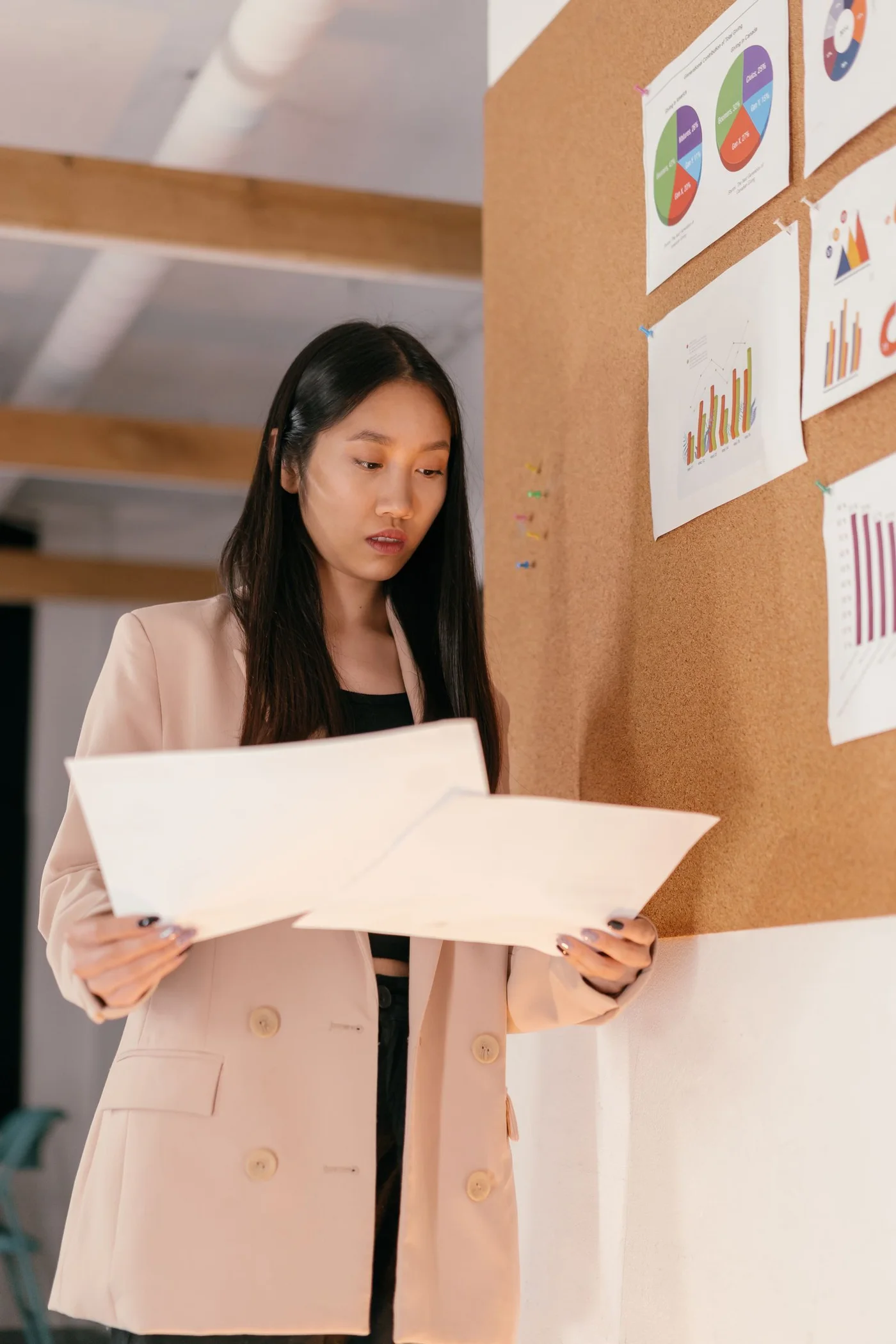 A woman reviewing financial charts on a bulletin board.