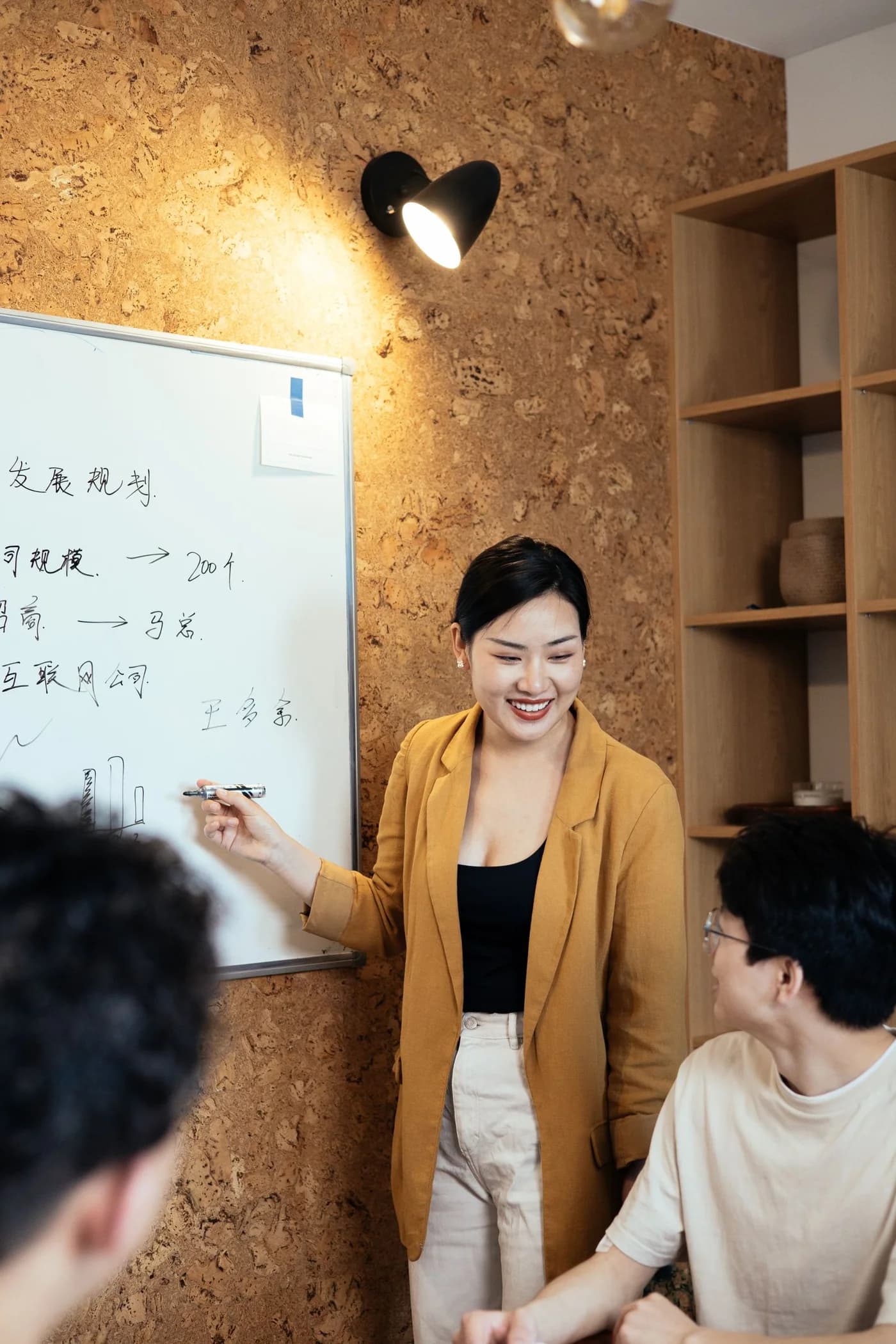 Colleagues planning a project beside a whiteboard.
