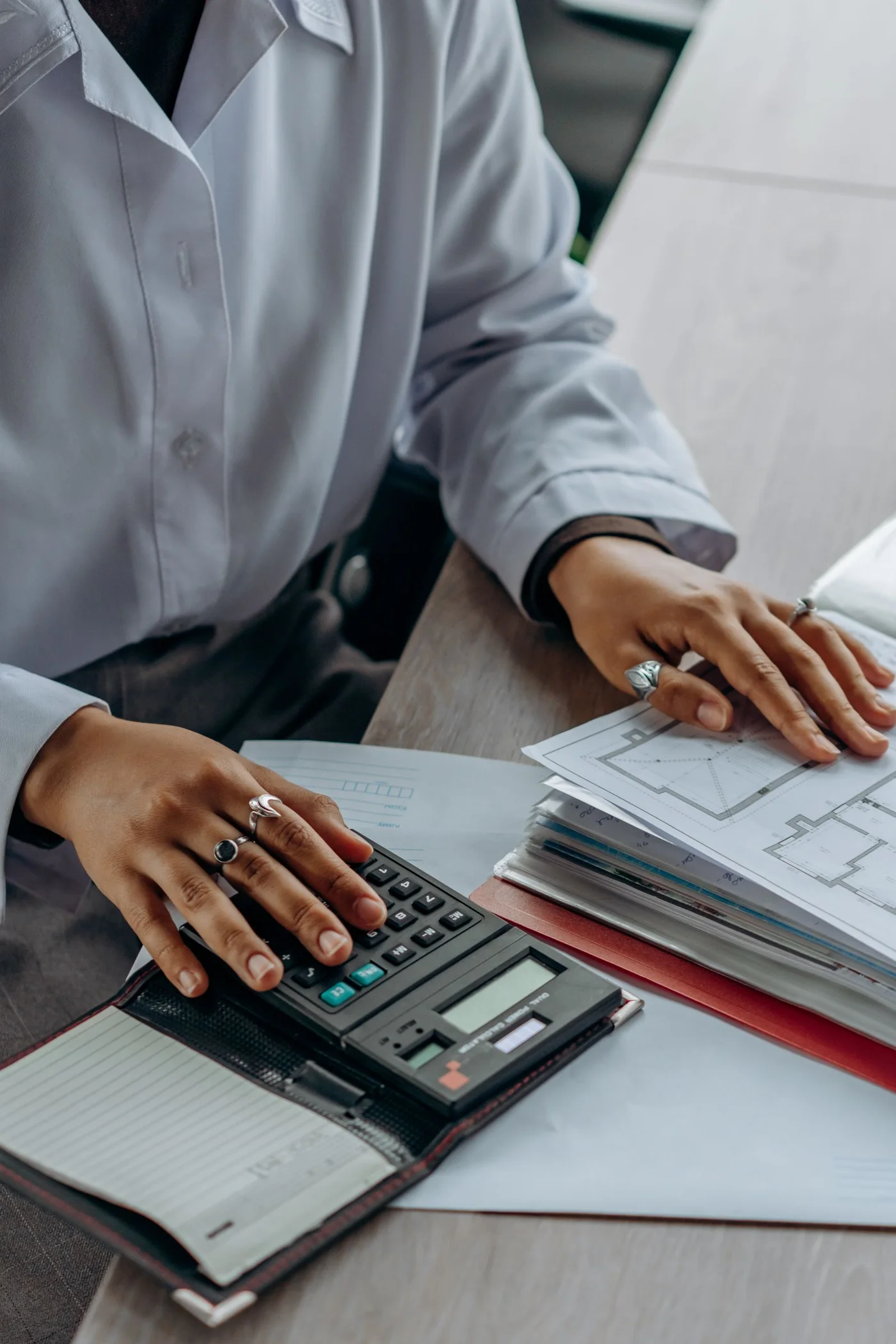 A professional checking financial documents with a calculator.