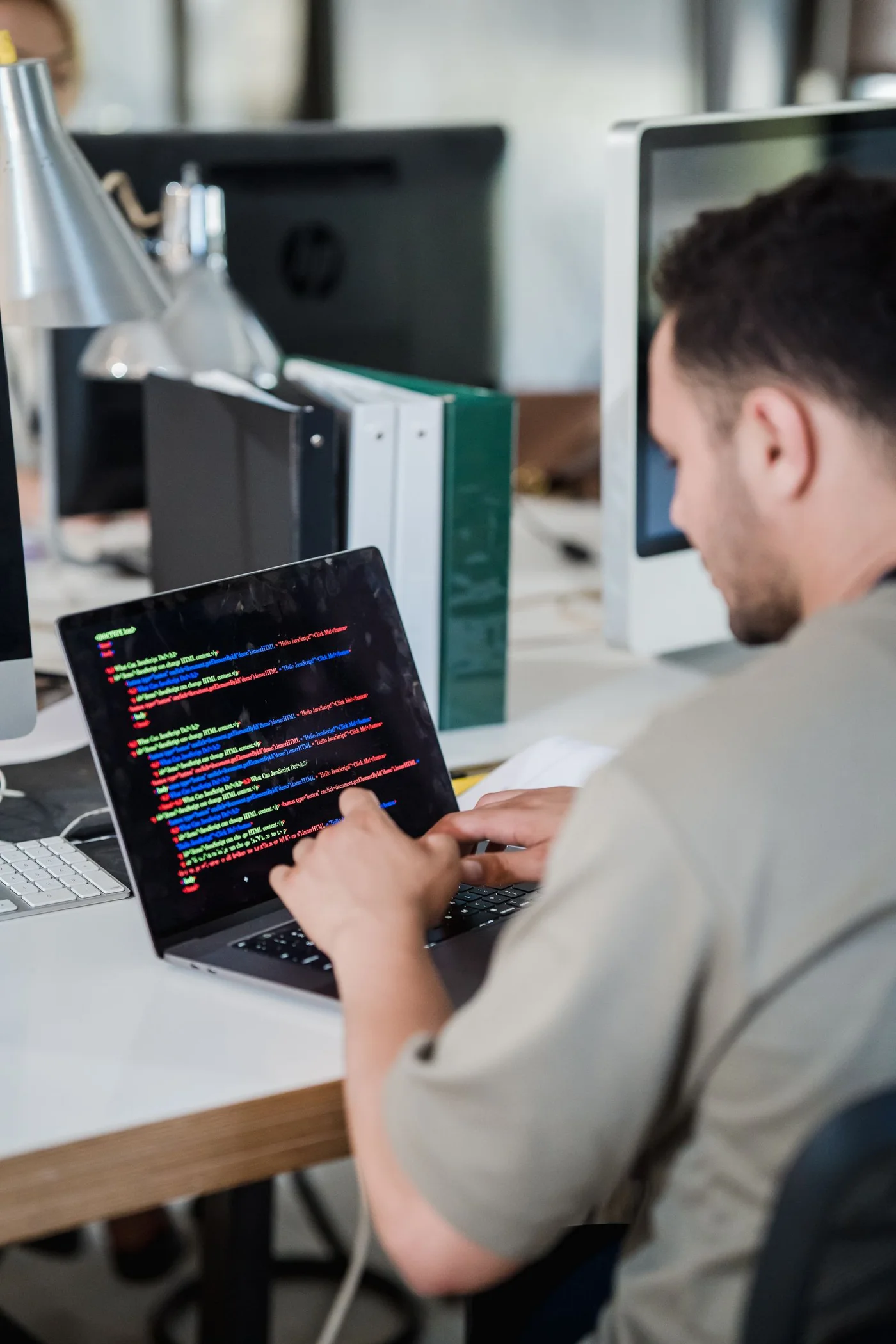 A developer writing code on a laptop.